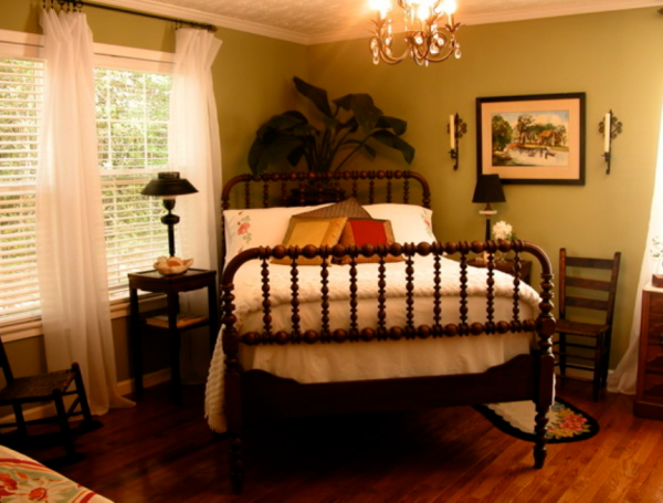 Kamar tidur dengan tempat tidur ditempatkan di pojok ruangan